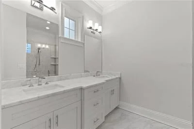 Dual white vanity with quartz countertop, framed mirror, and chrome fixtures in modern bathroom